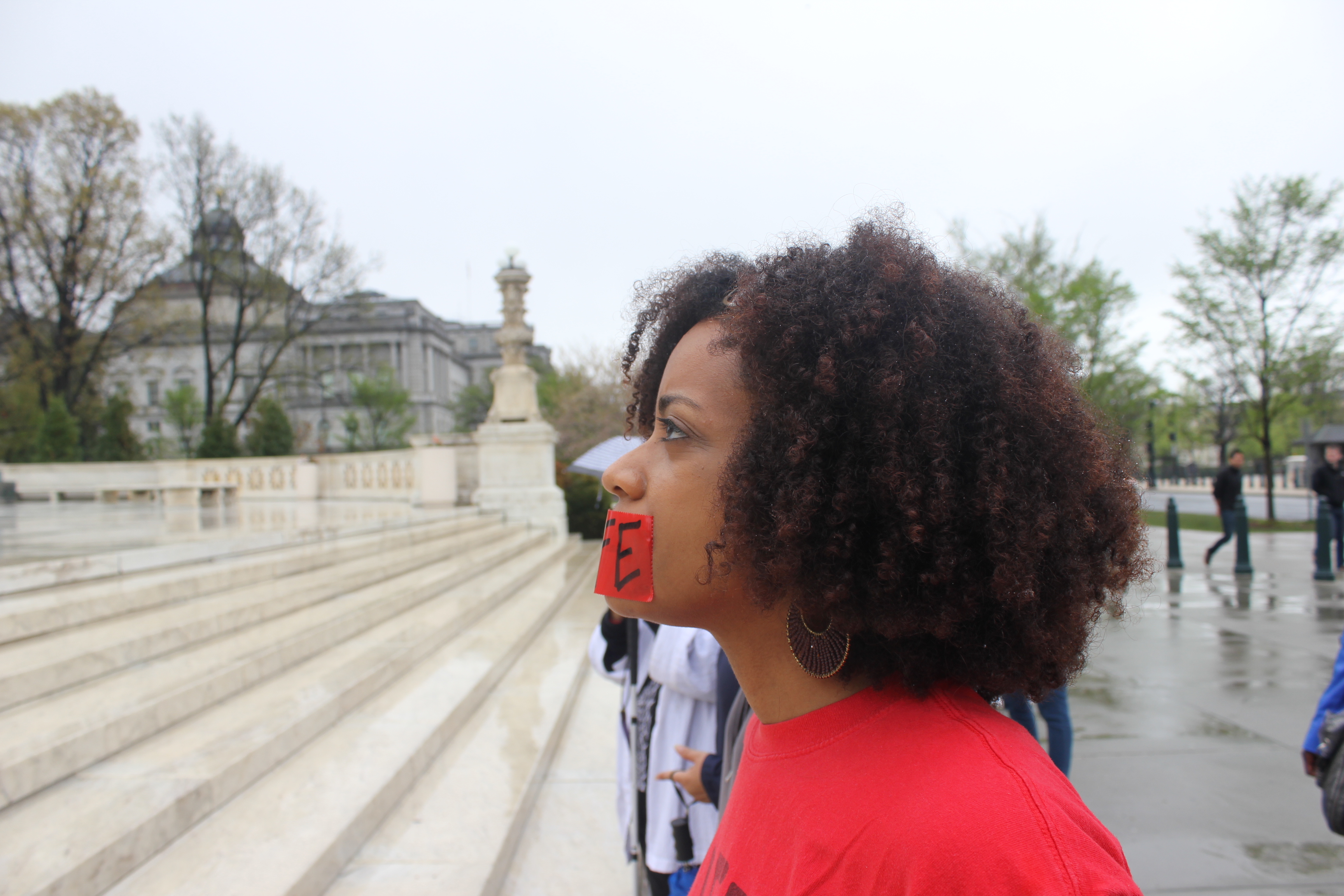 Black woman silently praying outside of U.S Supreme Court