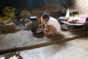 A Burmese woman cooks over an open fire.  (Photo credit: Heidi Miller)