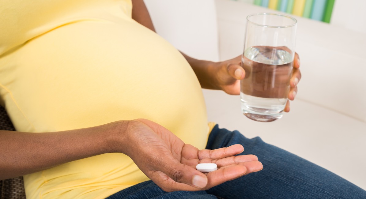 Pregnant Woman Taking Medicine At Home