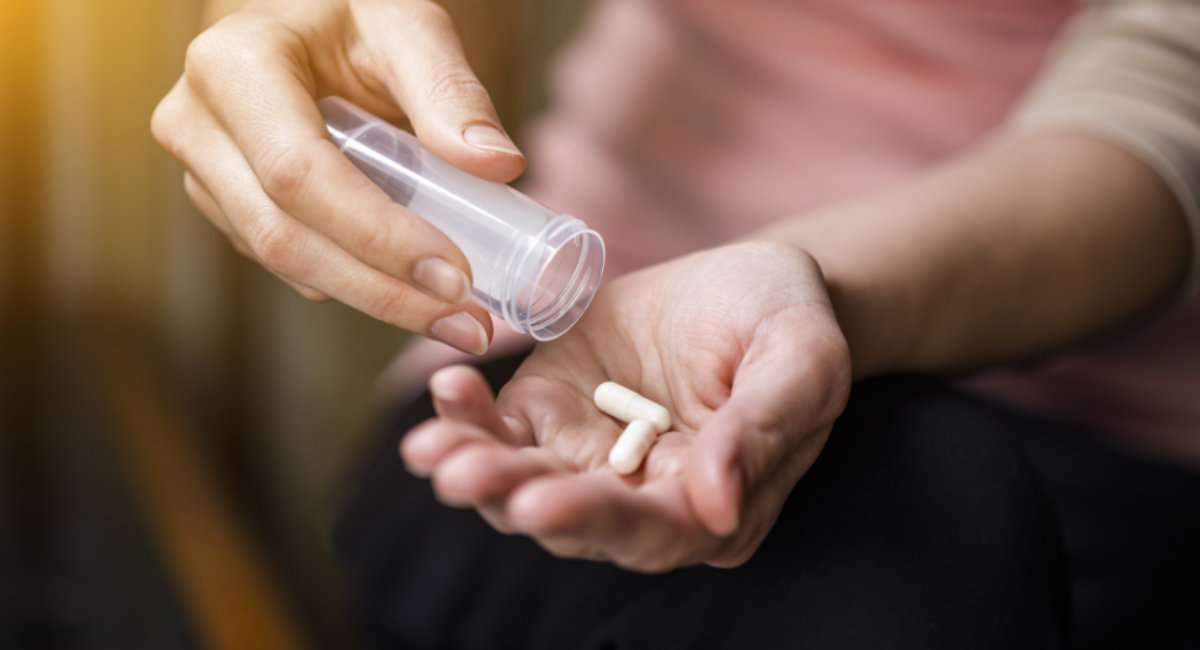 Woman taking pills close-up