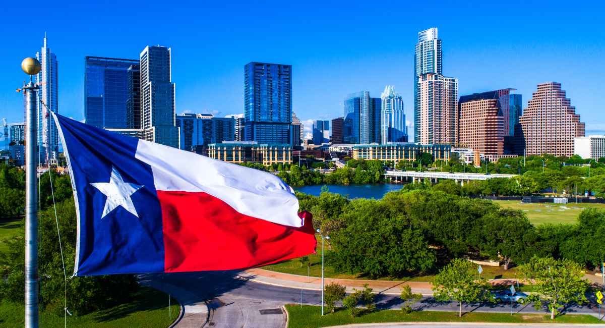 Perfect Texas flag flying in front of Austin Texas downtown skyline cityscape sunny perfect day