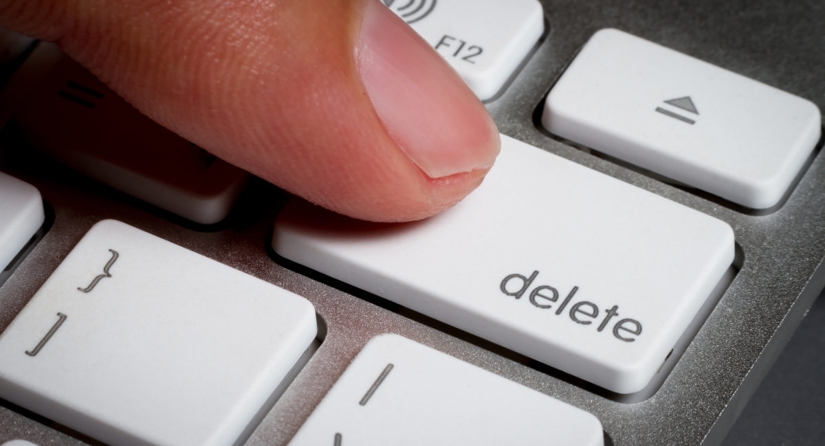Closeup of finger on delete key in a keyboard.