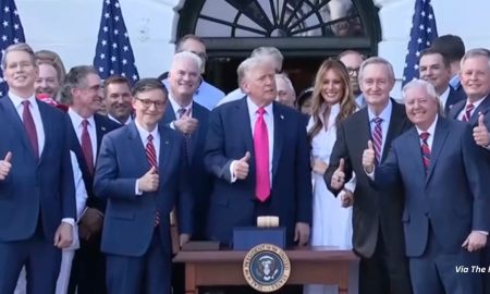 Trump gives a thumbs up after signing reconciliation bill surrounded by his wife Melania and federal legislators. The bill defunds Planned Parenthood for one year.