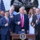 Trump gives a thumbs up after signing reconciliation bill surrounded by his wife Melania and federal legislators. The bill defunds Planned Parenthood for one year.